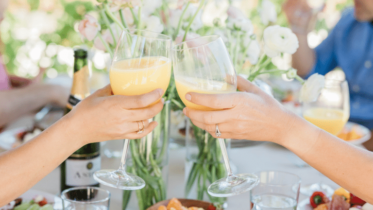 People toasting with mimosas at brunch