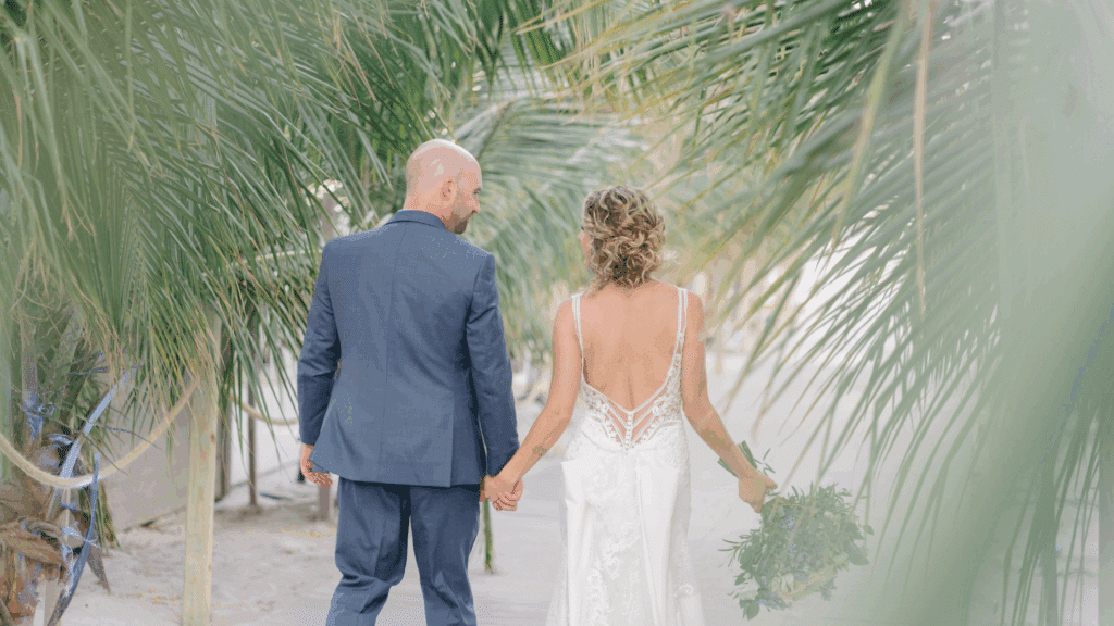 Bride and groom walking amongst palm trees at a luxury wedding