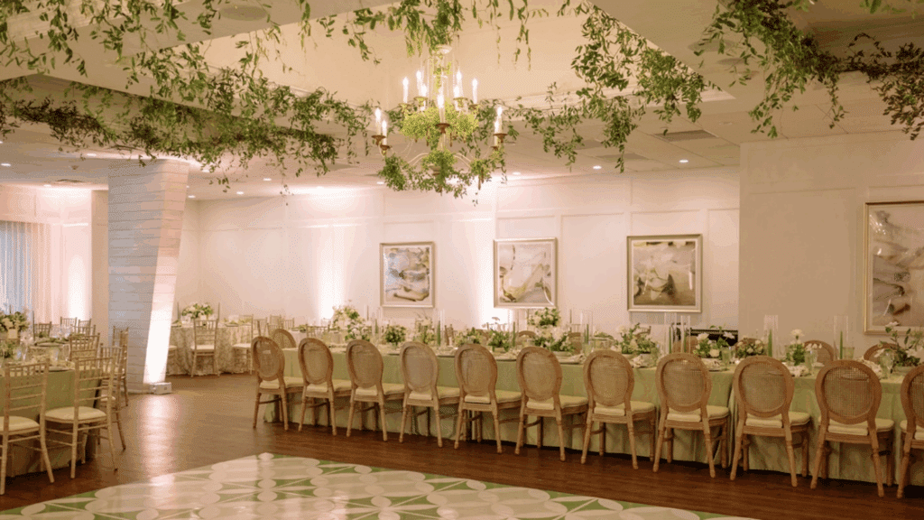 Luxurious ballroom wedding venue with greenery hanging from the ceiling
