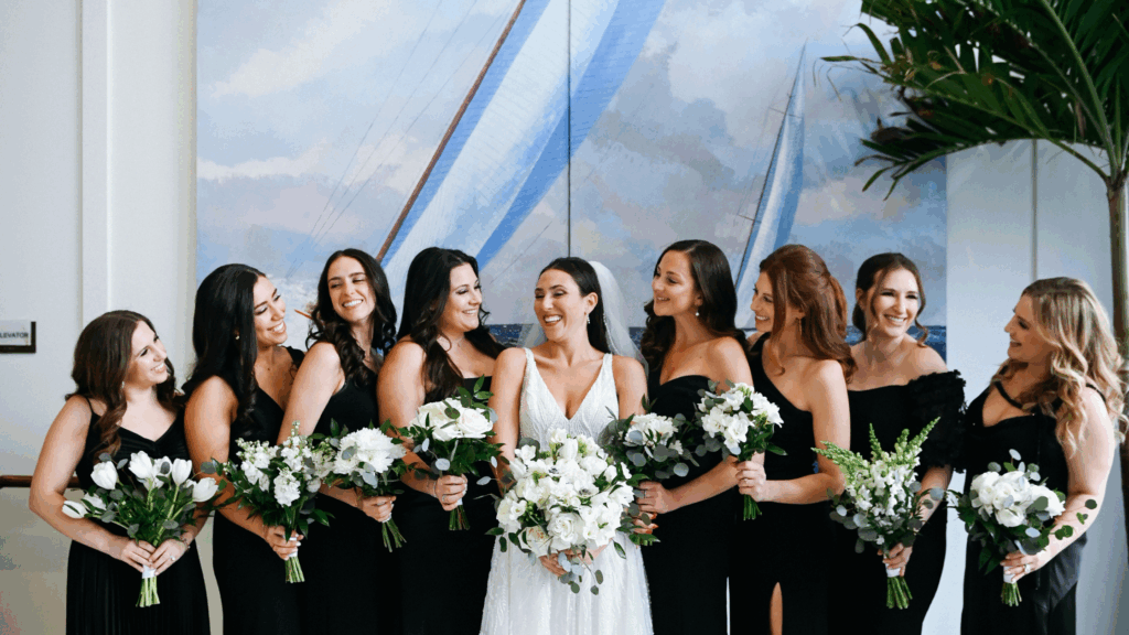 Bridal party posing in front of a painting