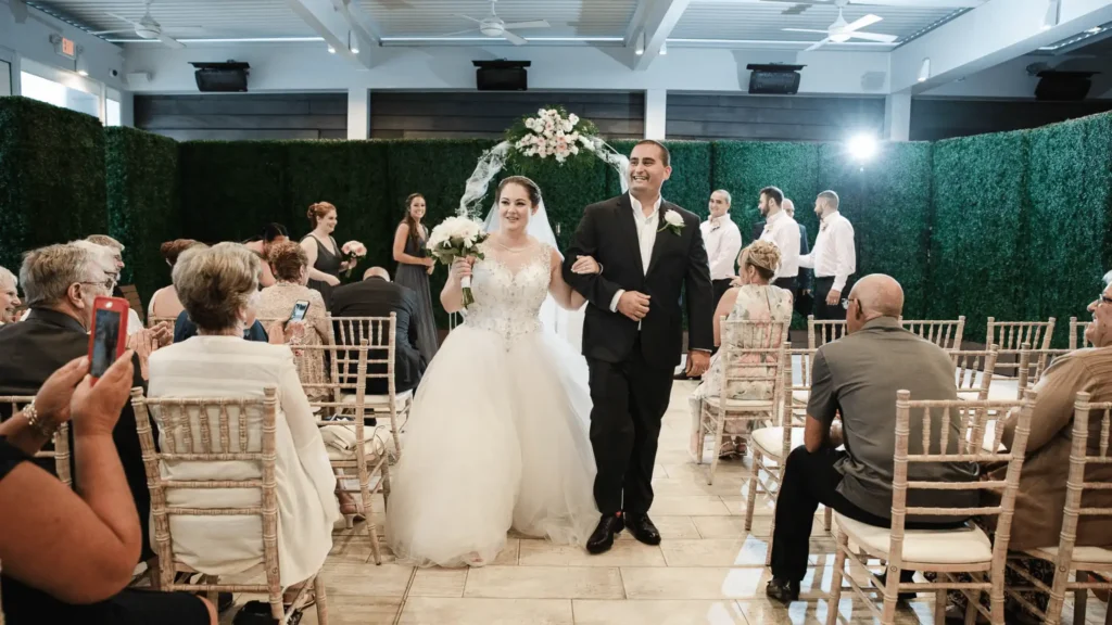 Bride wearing a ballgown walking down the aisle with her new husband