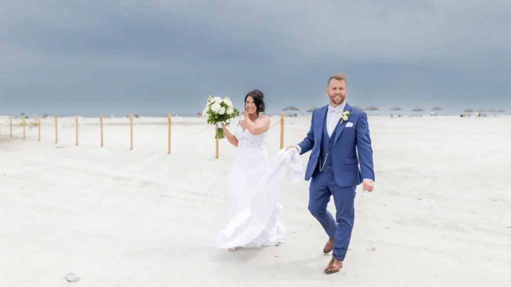 Candid photo of a bride and groom walking on the beach