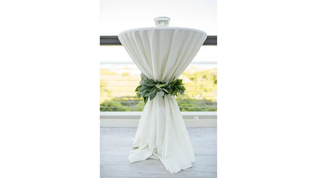 Table cloth on a high-top table tied with a garland of eucalyptus leaves